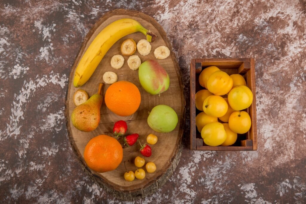 apple pear peaches wooden box with berries aside top view